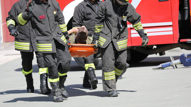 four firefightes and a injured person on the stretcher