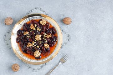 Homemade dried plum dessert with walnuts, traditional dessert with syrup