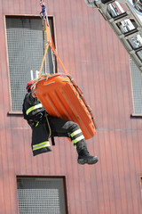 firefighter with orange stretcher on the crane