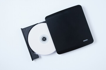 Black portable CD drive with CD. White background.