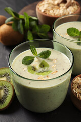 Glass of tasty kiwi smoothie with oatmeal on dark table