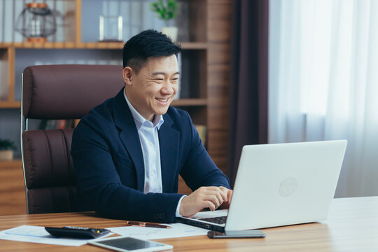 Young handsome asian man, businessman, lawyer, director talking on a video call from a laptop in the office, holds a meeting, consultation, discussion