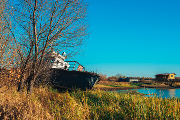 Fototapeta premium a ship in an autumn village by the water