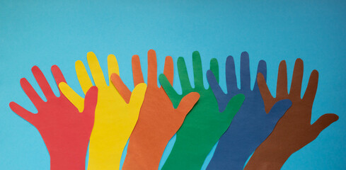 Abstract background open multicolored paper palms on a blue background.The concept of Autism Day and Youth Solidarity Day