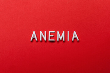 Word Anemia on red background, flat lay