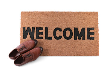 Stylish door mat with word Welcome and shoes on white background, top view