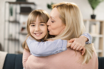 Happy loving single mom hugging cute little adopted kid daughter laughing bonding, young foster...