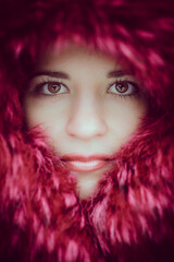 Close-up portrait of a woman wrapped in pink fur.