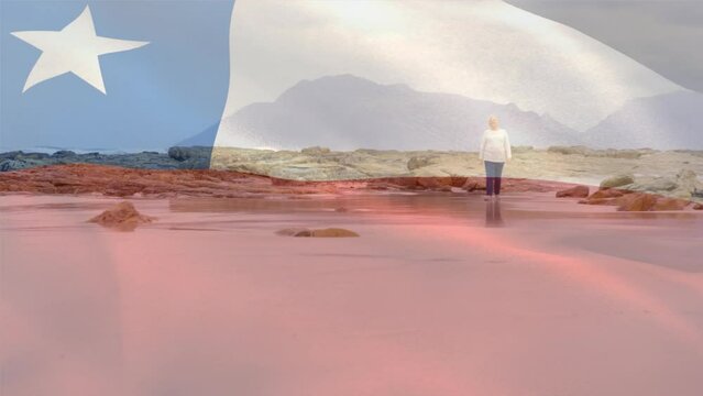 Animation of flag of chile over senior caucasian woman on beach