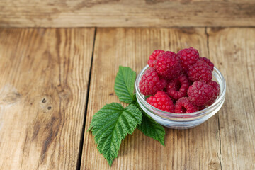 raspberries in a bowl on a wooden table