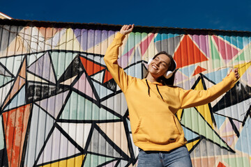 young smiling woman with headphones outdoor