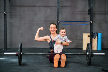 Obraz na płótnie Canvas Young fitness woman and a baby at the gym
