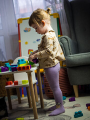 the child collects the designer at the table in the children's room