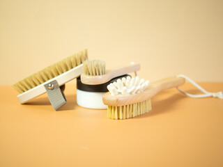On an orange background, accessories for spa treatments, brushes for face and body massage