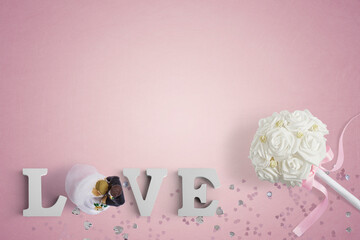 love letters, wedding bouquet and cake toppers on a pink background with copy space