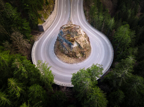 a highway road in a loop shape running through a forest