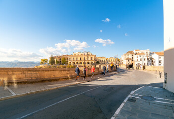 Tourists walk across the Puente Viejo Old Bridge towards the Old Town in the Andalusian city of...