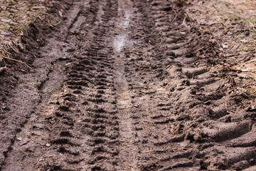 Traces of agricultural machinery on the wet rural road