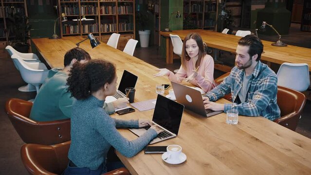 Confident young woman experienced worker teach multiethnic group of students