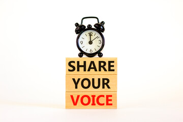 Share your voice symbol. Concept words Share your voice on wooden blocks. Beautiful white background. Black alarm clock. Business share your voice concept. Copy space.