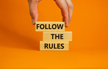 Follow the rules symbol. Concept words Follow the rules on wooden blocks. Businessman hand....