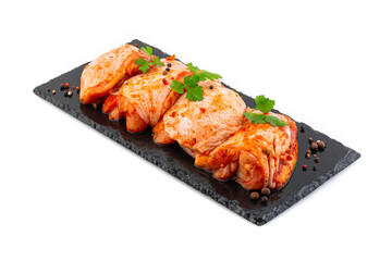 chicken thighs in marinade on a black plate