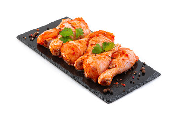 Сhicken drumsticks in marinade on a black plate