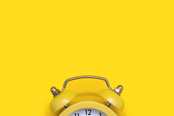 Yellow old-fashioned alarm clock with a dial on a yellow background with free space for text. The...