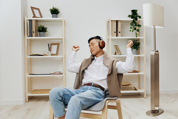 Fototapeta na wymiar teenager sweater on the shoulders headphones music sitting in the room Lifestyle