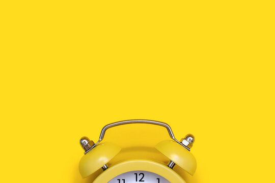 Yellow old-fashioned alarm clock with a dial on a yellow background with free space for text. The concept of time and responsibility. Vintage alarm clock with space for advertising