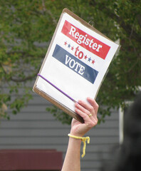 Sign in upraised hand at political rally urges people to register and vote, a key message as the...