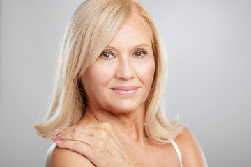 Portrait of beautiful blond senior woman posing and looking at the camera. Beauty photography