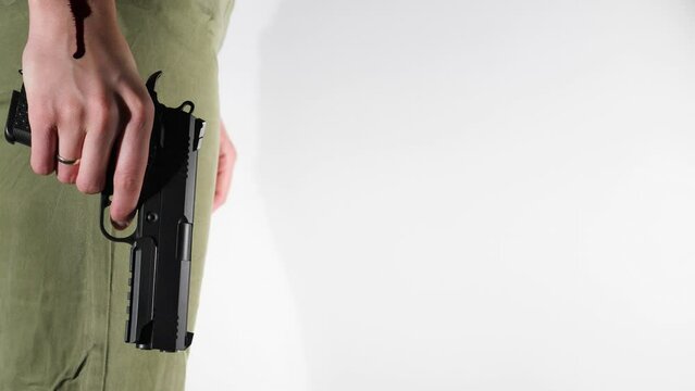 A woman's hand through which blood flows holds a gun on a white background