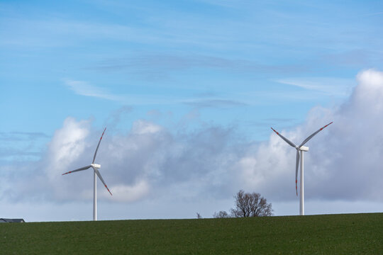 Two wind turbine in the field, blue skies and fluffy clouds