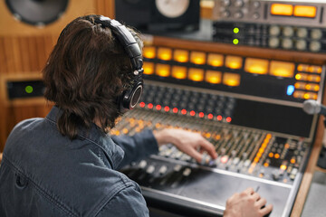 High angle at music producer operating audio workstation in professional recording studio, copy...