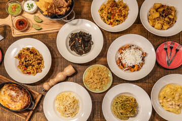 Overhead shot of Italian pasta dishes of all kinds with Parmesan cheese, truffle, tomatoes,...