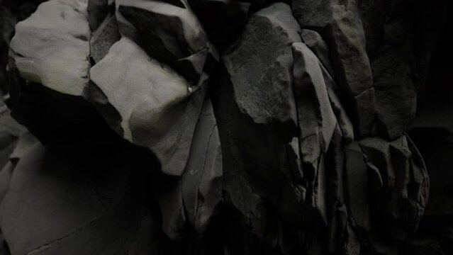 Close up detailed shot of famous basalt rocks on Reynisfjara Beach, Iceland. Volcanic geological formation. Travel destination, geology, beauty in nature and tourism concept. Slow Motion 4k Shot