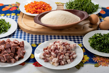  ingredients for preparing a recipe, bacon, cabbage, red bell pepper, manioc flour, egg, sausage, parsley, on a table