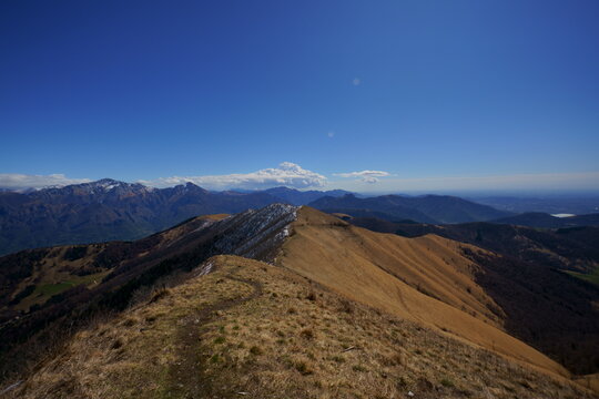 SENTIEROSULLA CRESTA DEDL MONTE SAN PRIMO PREALPI COMASCHE CON VISTA ALL'ORIZZONTE DELLE VETTE DEL GRUPPO DELLE GRIGNE 