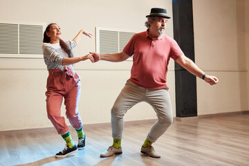 A man and a woman dancing Lindy Hop in a dance studio