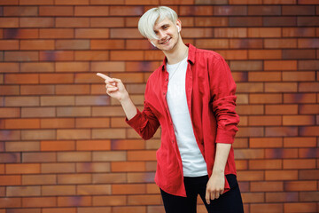 Young happy man pointing at something. Man showing an offer.