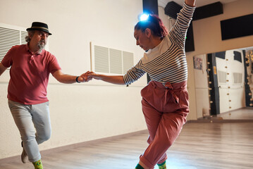 A man and a woman dancing Lindy Hop in a dance studio