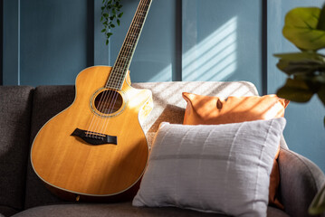 Acoustic guitar on a sofa in natural sunlight
