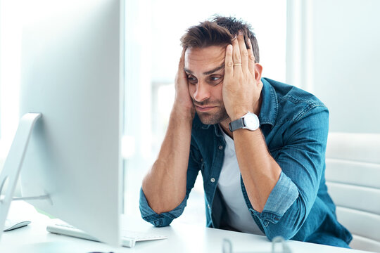 This Whole Situation Is Driving Me Crazy. Shot Of A Young Businessman Looking Overly Stressed Out In His Office.