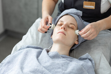 Young beautiful woman doing beauty treatment, massage in the salon.