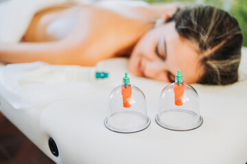 Suction cups placed beside of a female patient, by a massage therapist. Medical spa massage center.