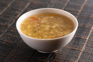 Egg drop soup isolated on a wooden table