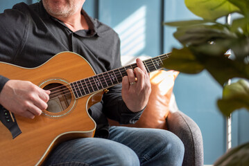 Obraz premium Midsection view of man playing acoustic guitar