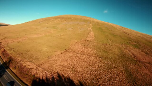 Aerial drone shot of Brecon Beacons with reservoir at the botom next to pen y fan peak. fast fpv view wales