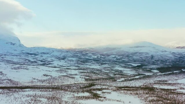 Aerial view of winter landscape in the north. Forests and mountains covered with snow top shot. 